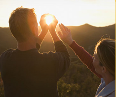 Man outlining the sun with his hands