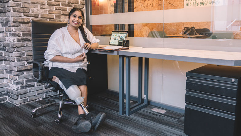 Woman with disability sitting in chair and smiling